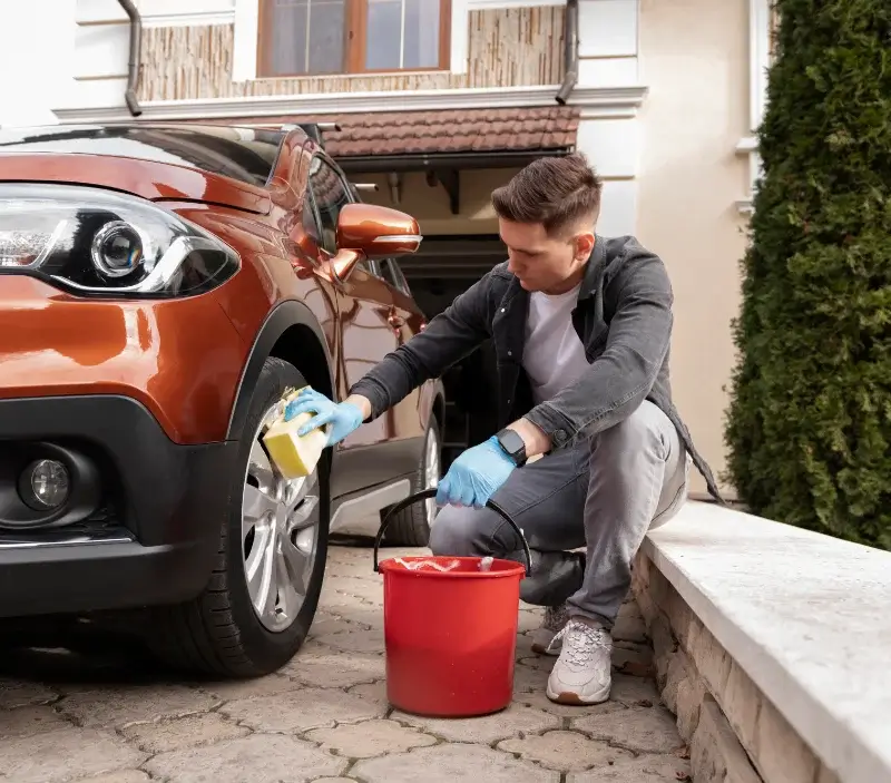 Lavage auto à domicile Saint-Laurent-de-Muret : professionnel intervenant sur un véhicule
